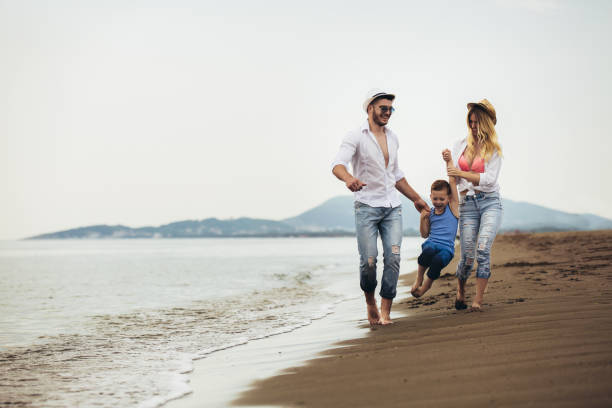 istock Parents Walking Along Beach With Child On Summer Vacation 1139012999