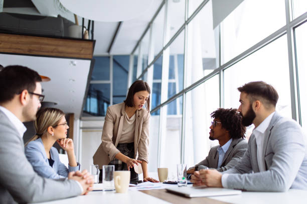 istock Female manager stands addressing team at board meeting 1139013247