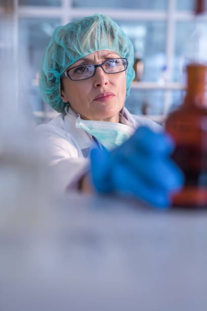 istock Female biochemist taking glass bottle in laboratory. 1139014687