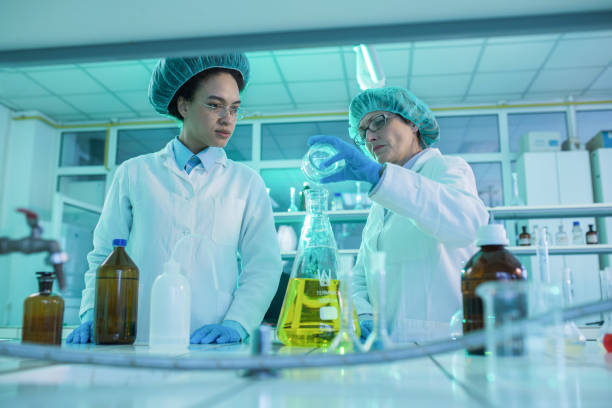 istock Female scientists cooperating while mixing chemical substances in laboratory. 1139014728
