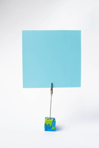 istock Note sheet inscriptions. Pink, blue, filet paper on a clothespin holder on white background, text space. Place for inscription. 1139016736