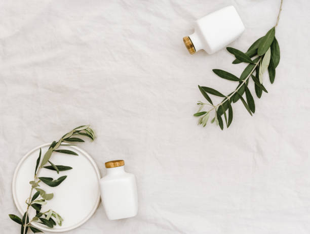 istock Minimal lifestyle background. Flat lay composition with ceramic bottles and olive branches on linen 1139019503