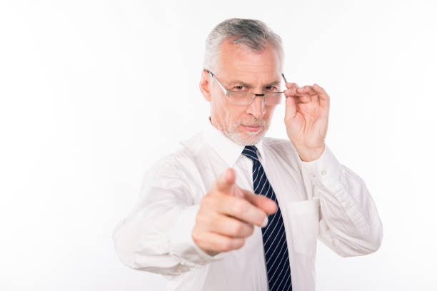 istock Old businessman holding his glasses pointing straight 1139031972