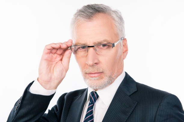 istock handsome serios businessman with gray beard holding glasses 1139033127