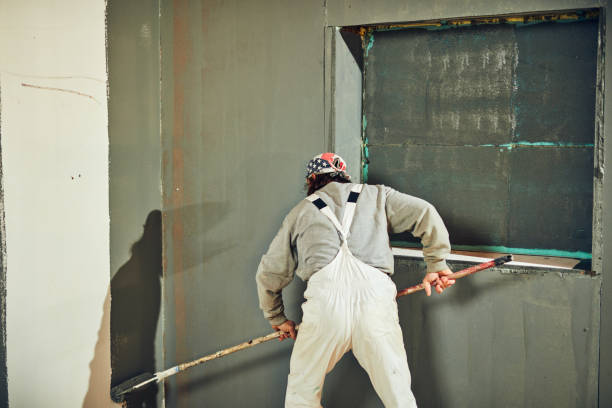 istock Painter painting walls with a extender roller indoors. 1139033606