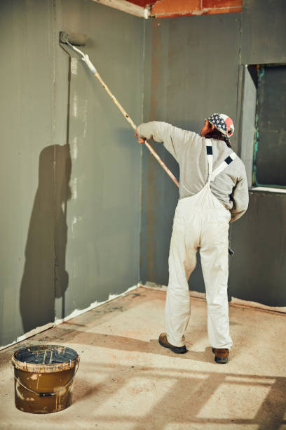 istock Painter painting walls with a extender roller indoors. 1139034338