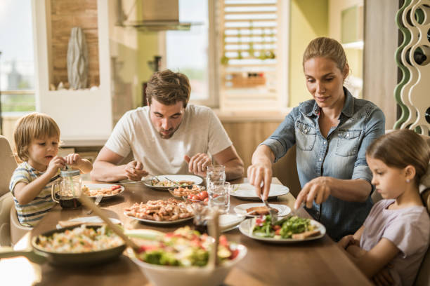 istock Young family having lunch together at dining table. 1139034404