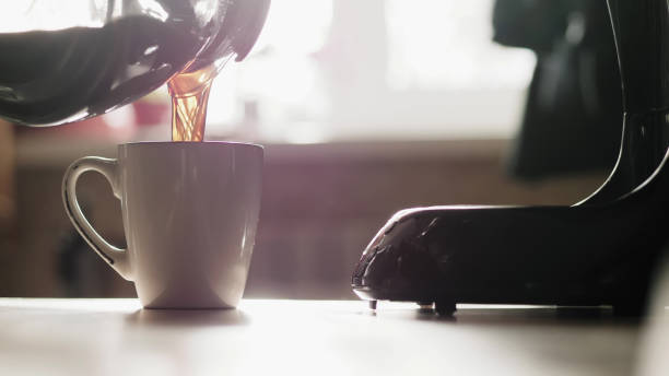 Pouring coffee into a cup from a glass bowl