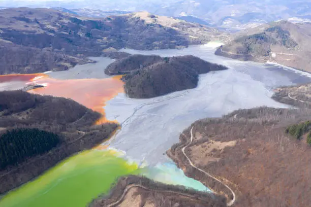 Aerial view of a lake filled with chemical residuals from copper mine exploitation by drone. Geamana, Rosia Montana, Romania