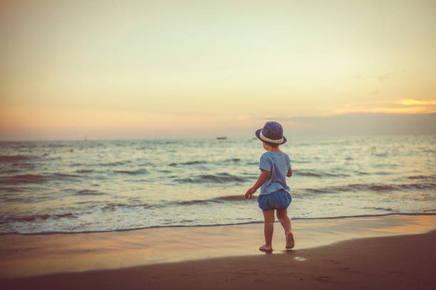 Happy child enjoying sunset near the sea