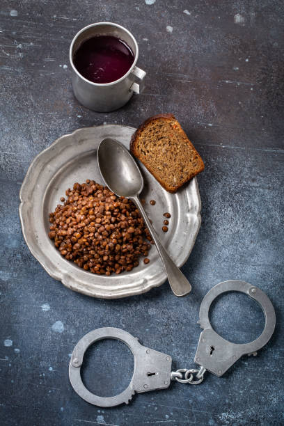 Prison food and handcuff above Prison food and handcuff in a grunge setting. Poor and lacking nutrition prison meal stock pictures, royalty-free photos & images