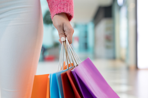 Woman holding colorful shopping bags in mall