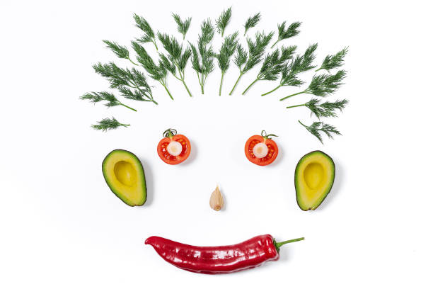 istock Funny face from different vegetables tomatoes, cucumber, onion, parsley, pepper, garlic, avocado on white background. 1139043258