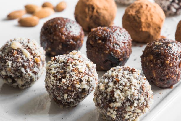Homemade energy bites, vegan chocolate truffle with cacao and coconut flakes. Concept healthy food. Homemade energy bites, vegan chocolate truffle with nuts, cacao and coconut flakes. Concept healthy food. Close up. plasma ball stock pictures, royalty-free photos & images