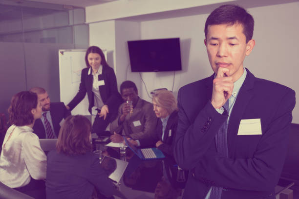 istock team discussing with upset Chinese man foreground 1139047696