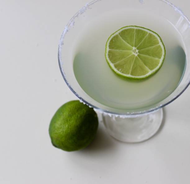 istock coctail in a martini glass and lime on white background 1139047842