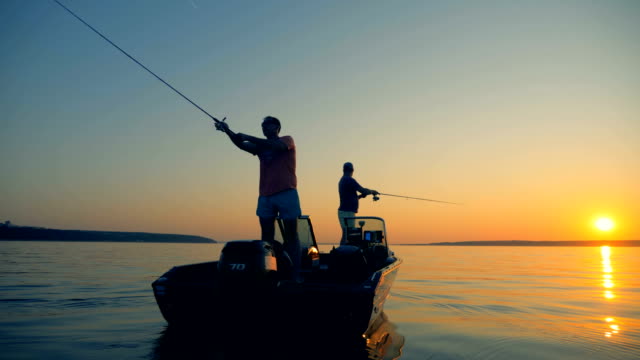 Men are catching fish from an autoboat in the open water