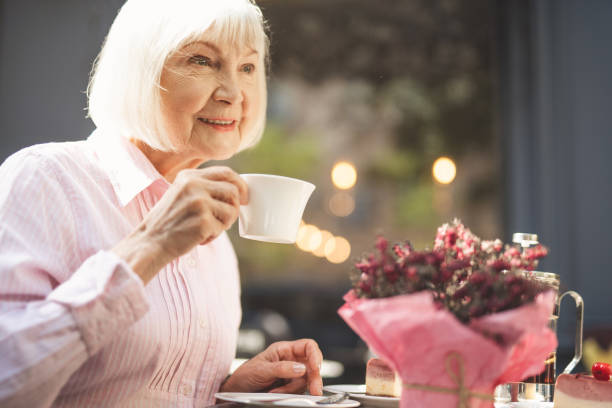 istock Smiling old lady drinking hot drink outside 1139049289