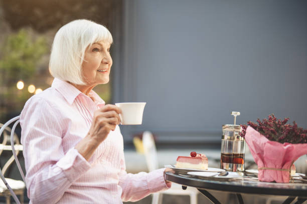 istock Cheerful senior lady drinking hot drink outdoors 1139049292