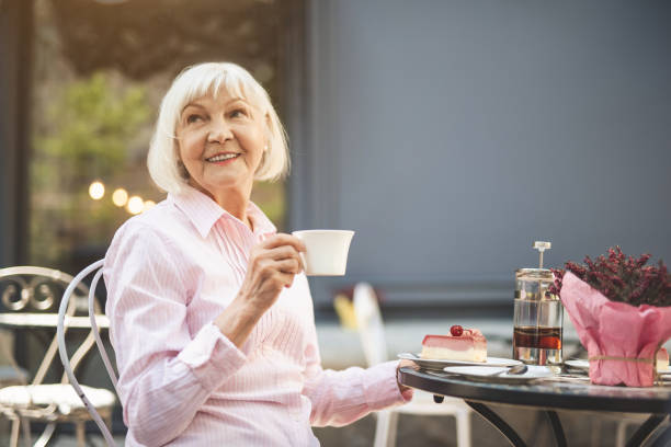 istock Happy old woman spending evening in cafe outside 1139049295