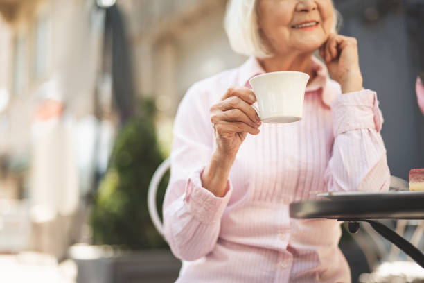 istock Delighted old lady drinking hot drink outdoors 1139049296