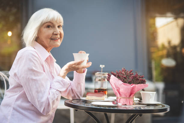 istock Old happy female drinking hot drink outside 1139049298