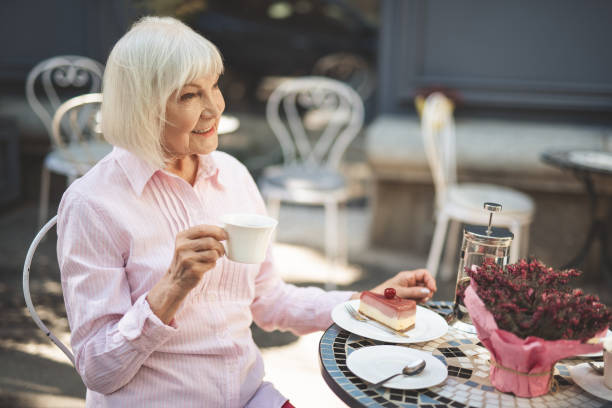 istock Delighted old woman sitting at table outside 1139049322