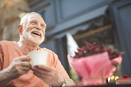 El anciano sonriente bebiendo té al aire libre photo