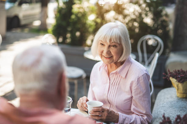 istock Delighted senior woman talking to man at table 1139049350