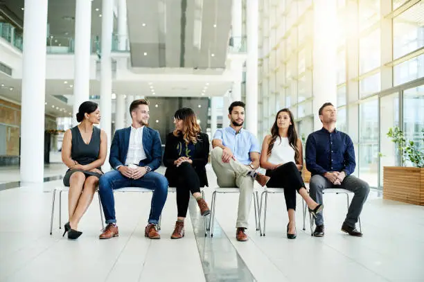 Shot of a group of businesspeople sitting in line in an office