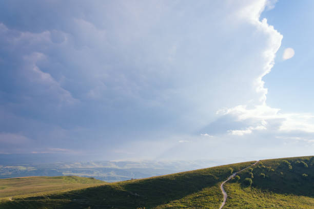 istock Mountain road stretching into the distance clouds on a summer day. 1139052975