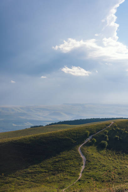 istock Mountain road stretching into the distance clouds on a summer day. 1139052982