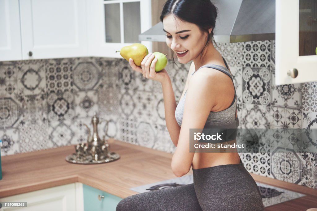 Beautiful woman with healthy food fruit in the kitchen. Beautiful woman with healthy food fruit in the kitchen Adult Stock Photo Beautiful woman with healthy food fruit in the kitchen. Beautiful woman with healthy food fruit in the kitchen Adult Stock Photo