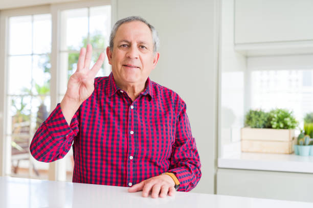 istock Handsome senior man at home showing and pointing up with fingers number three while smiling confident and happy. 1139056102