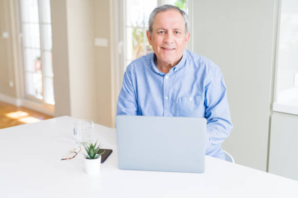 istock Handsome senior man using laptop and smiling 1139056498