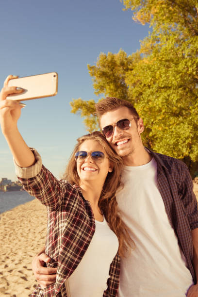 istock Couple in love making seifie on the beach 1139056578