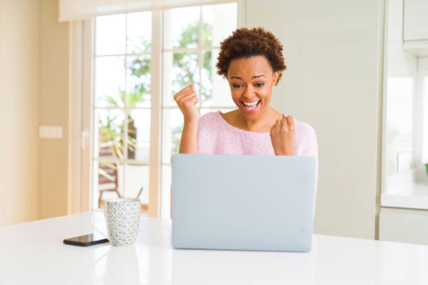 istock Young african american woman working using computer laptop very happy and excited doing winner gesture with arms raised, smiling and screaming for success. Celebration concept. 1139057077