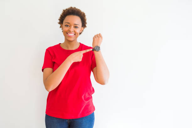 young beautiful african american woman over white background in hurry pointing to watch time, impatience, upset and angry for deadline delay - clock face clock deadline human hand imagens e fotografias de stock