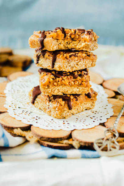 Organic homemade granola bars with salt date caramel and chocolate on blue background.Selective focus.A cup of coffee. Healthy breakfast. stock photo