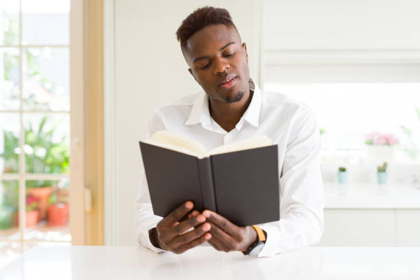 istock Young african man reading a book, studying for univeristy 1139060150
