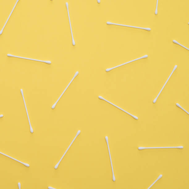 istock White cotton swabs on yellow background lie in random order. 1139060931