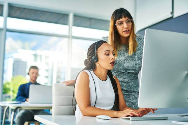 Putting their heads together to solve the problem Shot of two young women working together in a call centre day 1 stock pictures, royalty-free photos & images