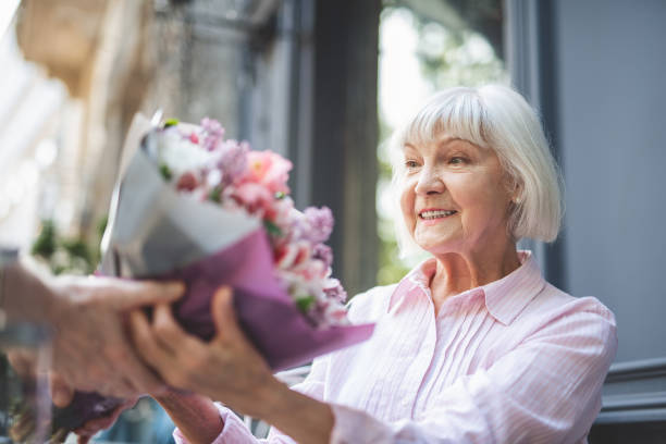 istock Delighted elderly female taking posy at date 1139063727