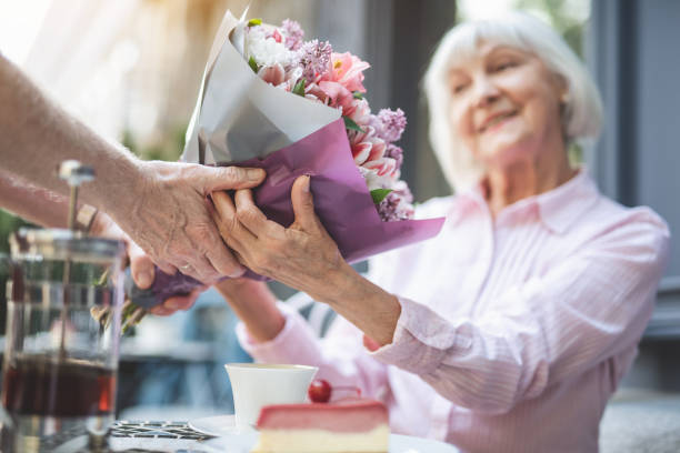 istock Happy old woman accepting posy from man 1139063732