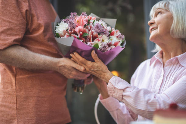 istock Glad old lady accepting posies from man 1139063746