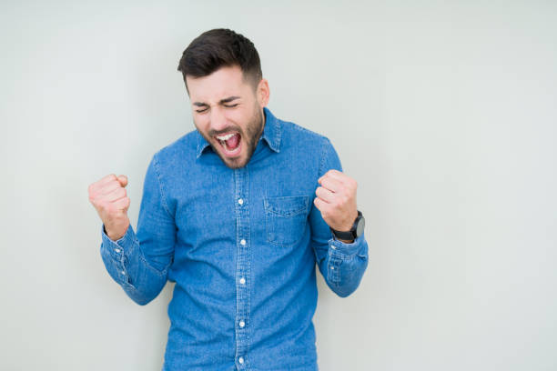 istock Young handsome man over isolated background very happy and excited doing winner gesture with arms raised, smiling and screaming for success. Celebration concept. 1139064508