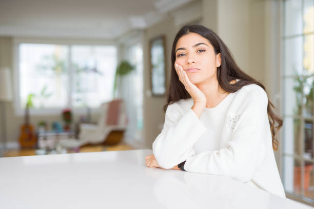 istock Young beautiful woman at home on white table thinking looking tired and bored with depression problems with crossed arms. 1139065963