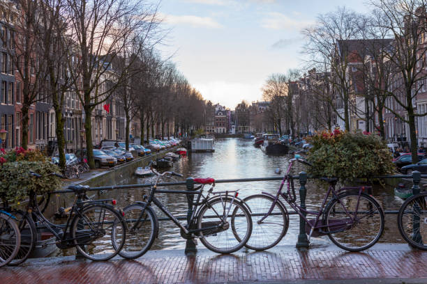 Amsterdam, Netherlands - Dec 14, 2017: Bicycle on Amsterdam street near water canal. Bicycle is very popular transport in Amsterdam. The Netherlands.