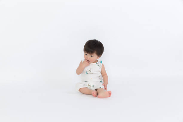 istock Happy child is sitting on floor, isolated over white 1139070251