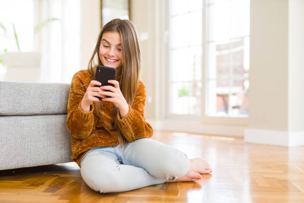 istock Beautiful young girl kid sending a message using smartphone with a happy face standing and smiling with a confident smile showing teeth 1139070646